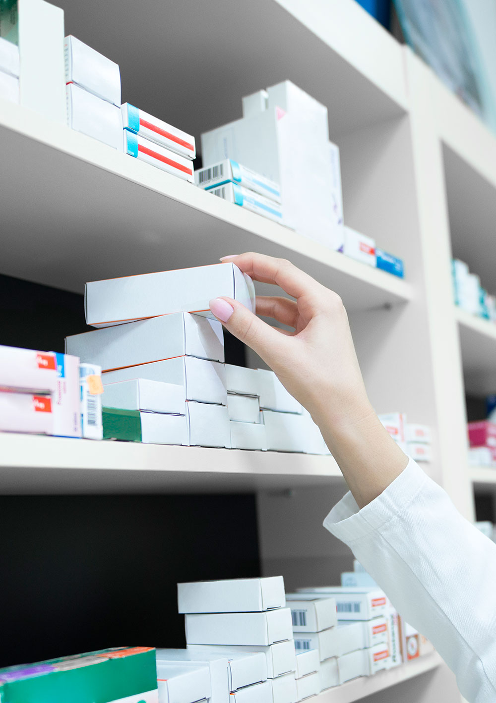 Closeup View of Pharmacist Hand Taking Medicine From Shelf in a Drug Store